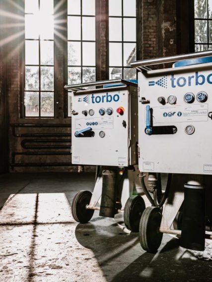 Torbo M120 Feuchtsandstrahlgerät in leerer Lagerhalle mit großen Fenstern