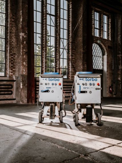 Torbo M120 Feuchtsandstrahlgerät in leerer Lagerhalle mit großen Fenstern